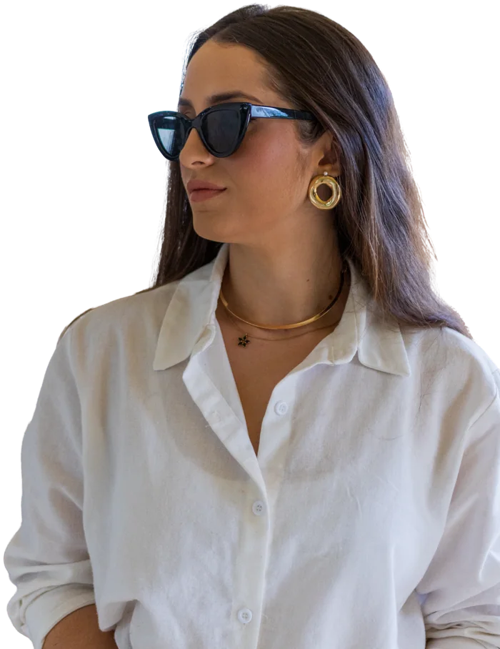 Tarcylla Moura de óculos escuros e camisa branca, olhando para o lado